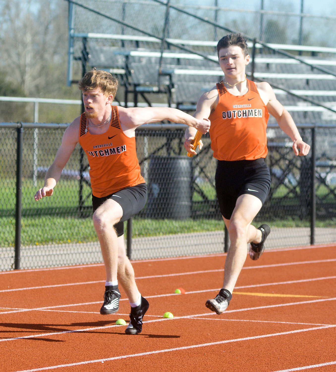 Alan Kopp (far right) hands the baton to Charlie Whelan during the boys 4x200-meter relay also at the OHS Relays.